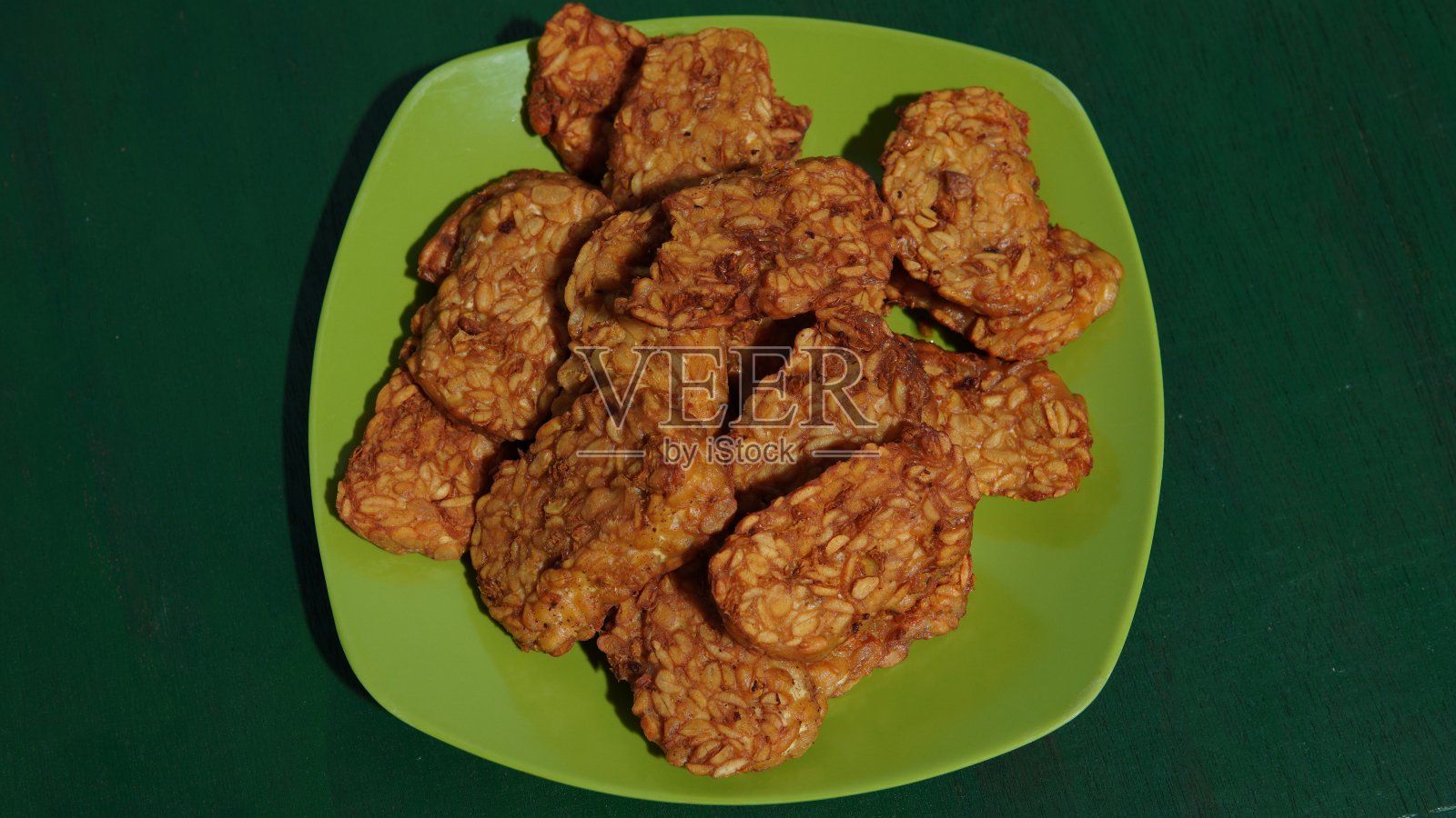 这是一种典型的印尼食物,叫做Tempe goreng(油炸豆豉)。由发酵大豆制成的印尼食品照片摄影图片