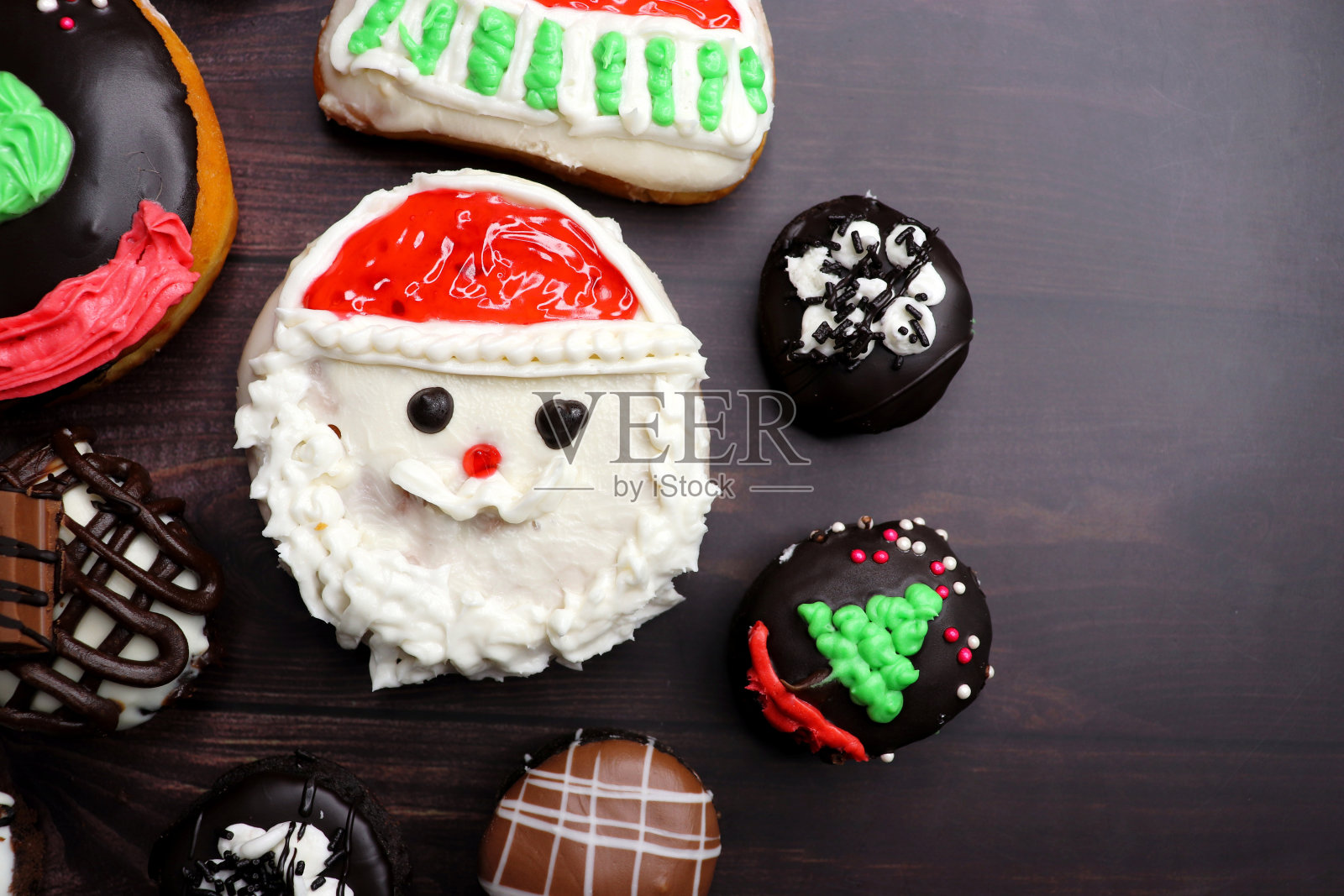 自制釉面圣诞甜甜圈。各式各样的圣诞设计甜甜圈,如驯鹿、圣诞老人、圣诞树和巧克力。节日的背景。副本的空间。节日或假日的概念。照片摄影图片