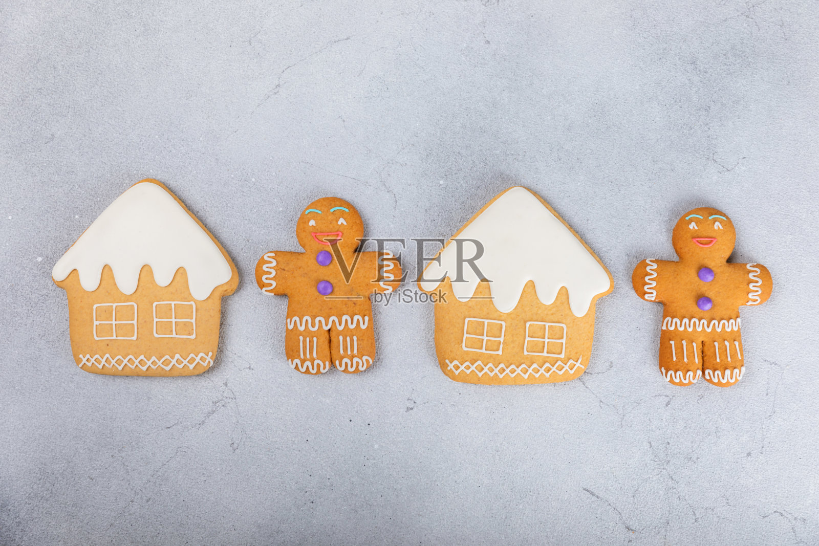 圣诞快乐!饼干姜饼屋和姜饼人与糖霜纹理表的背景。大气的圣诞糖果。姜饼。圣诞饼干。放文字的地方。副本的空间。照片摄影图片