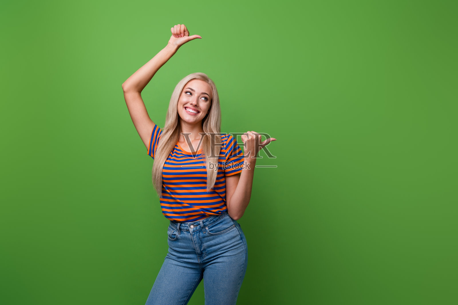可爱的女人穿着条纹t恤的照片肖像,手指指向横幅,空白空间在绿色背景上孤立照片摄影图片