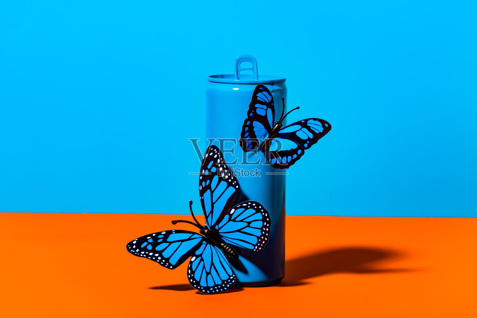 蓝色金属罐上的塑料蝴蝶照片摄影图片