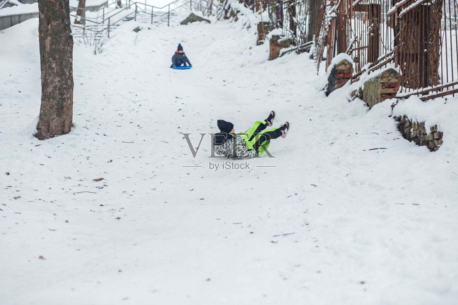 小女孩骑在雪板上。户外玩耍。寒冷的温度。冬天照片摄影图片