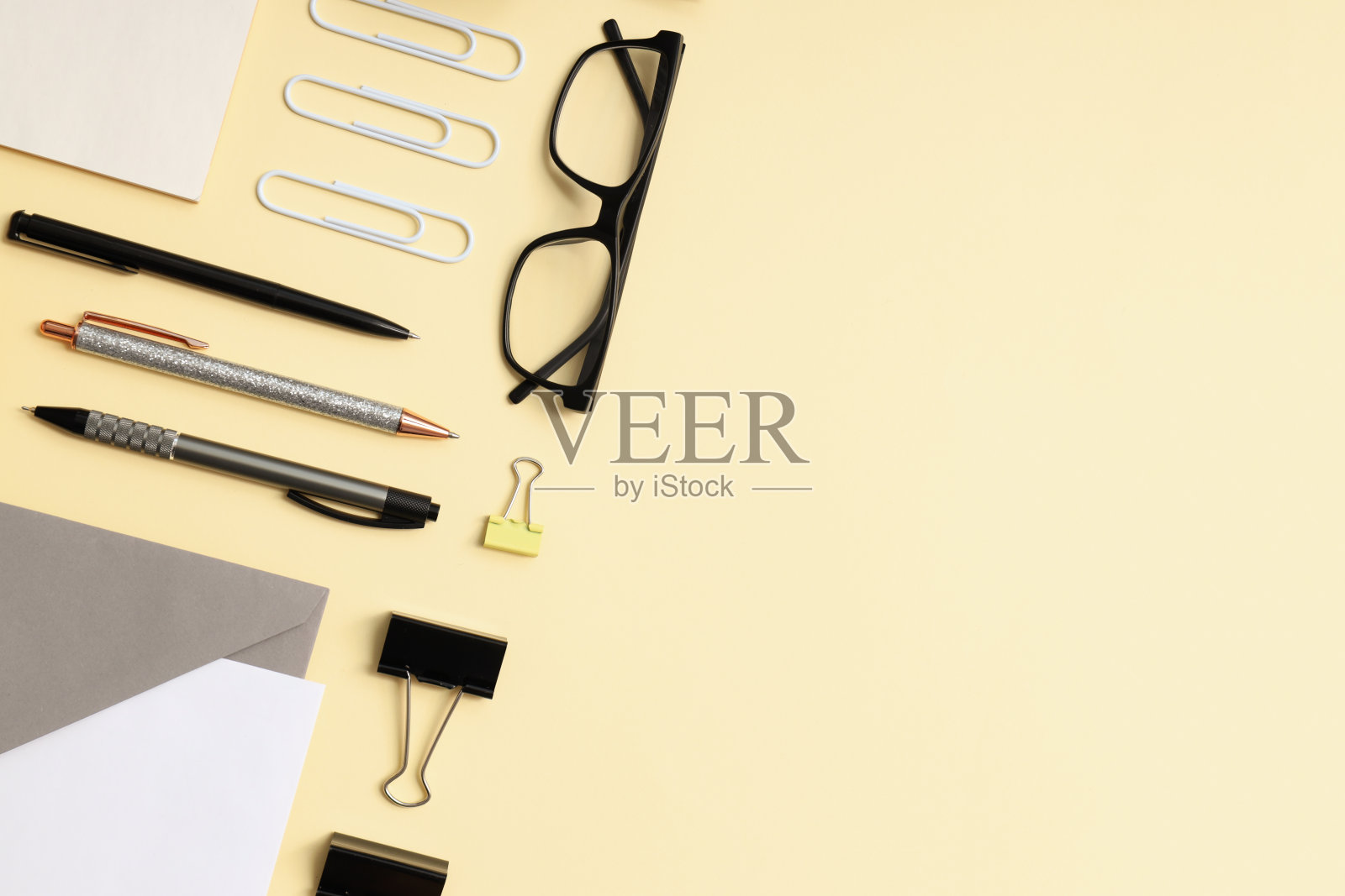 在米色的背景下,以不同的办公配件为基础的平面模型照片摄影图片