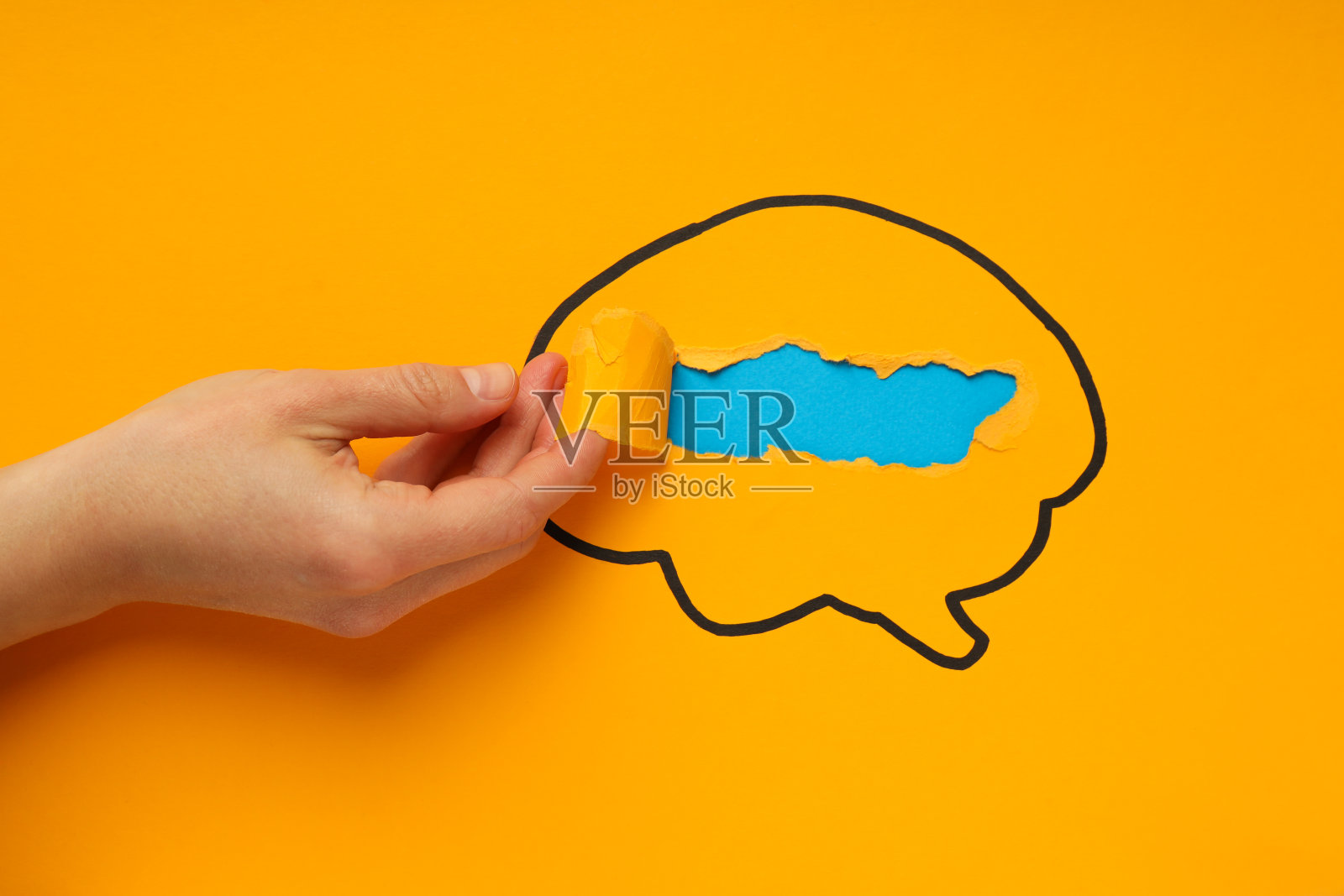 黄色背景的大脑和女性的手照片摄影图片