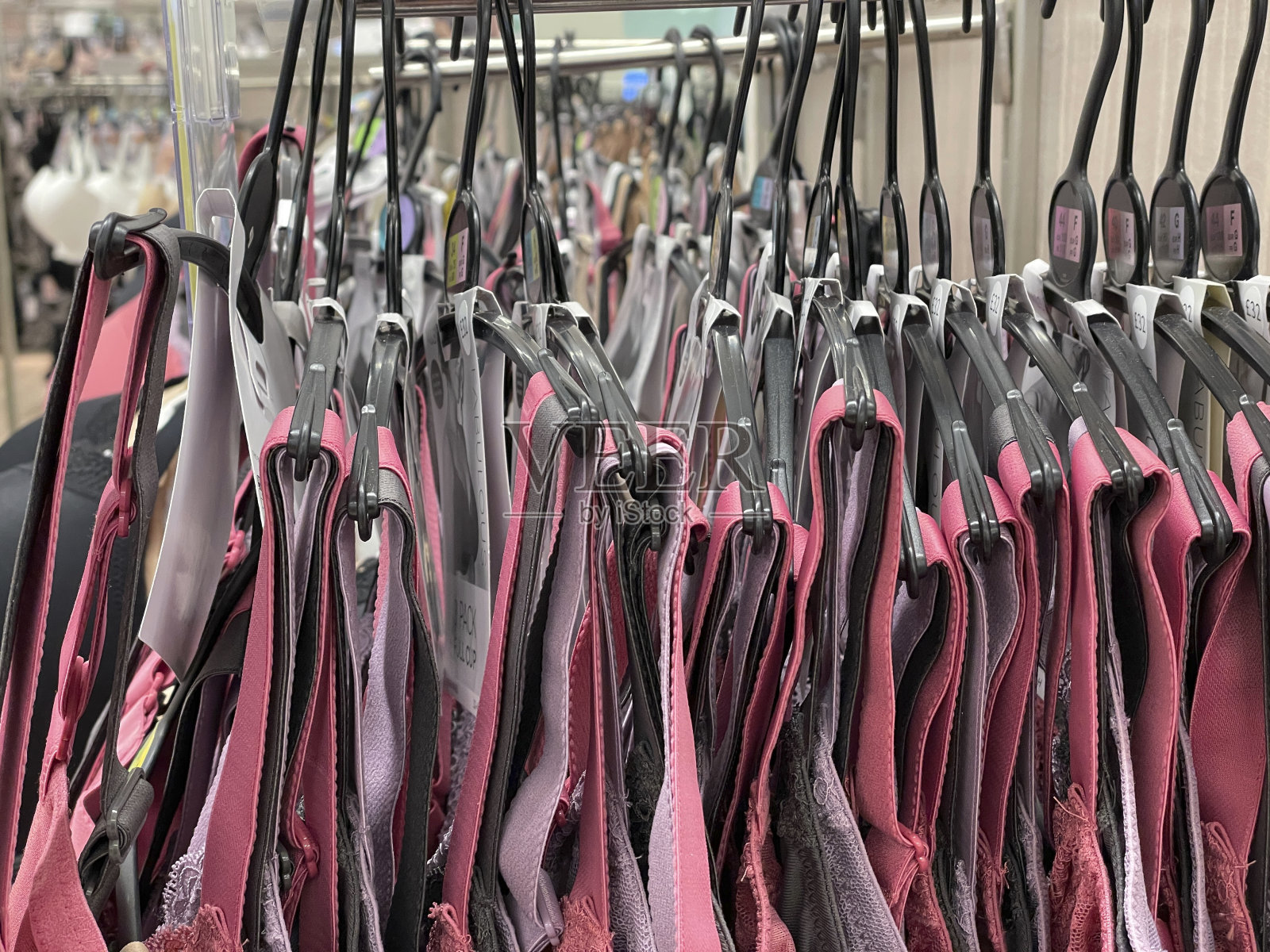 内衣店里挂着一排胸罩,彩色的胸罩带紧扣,健康照片摄影图片