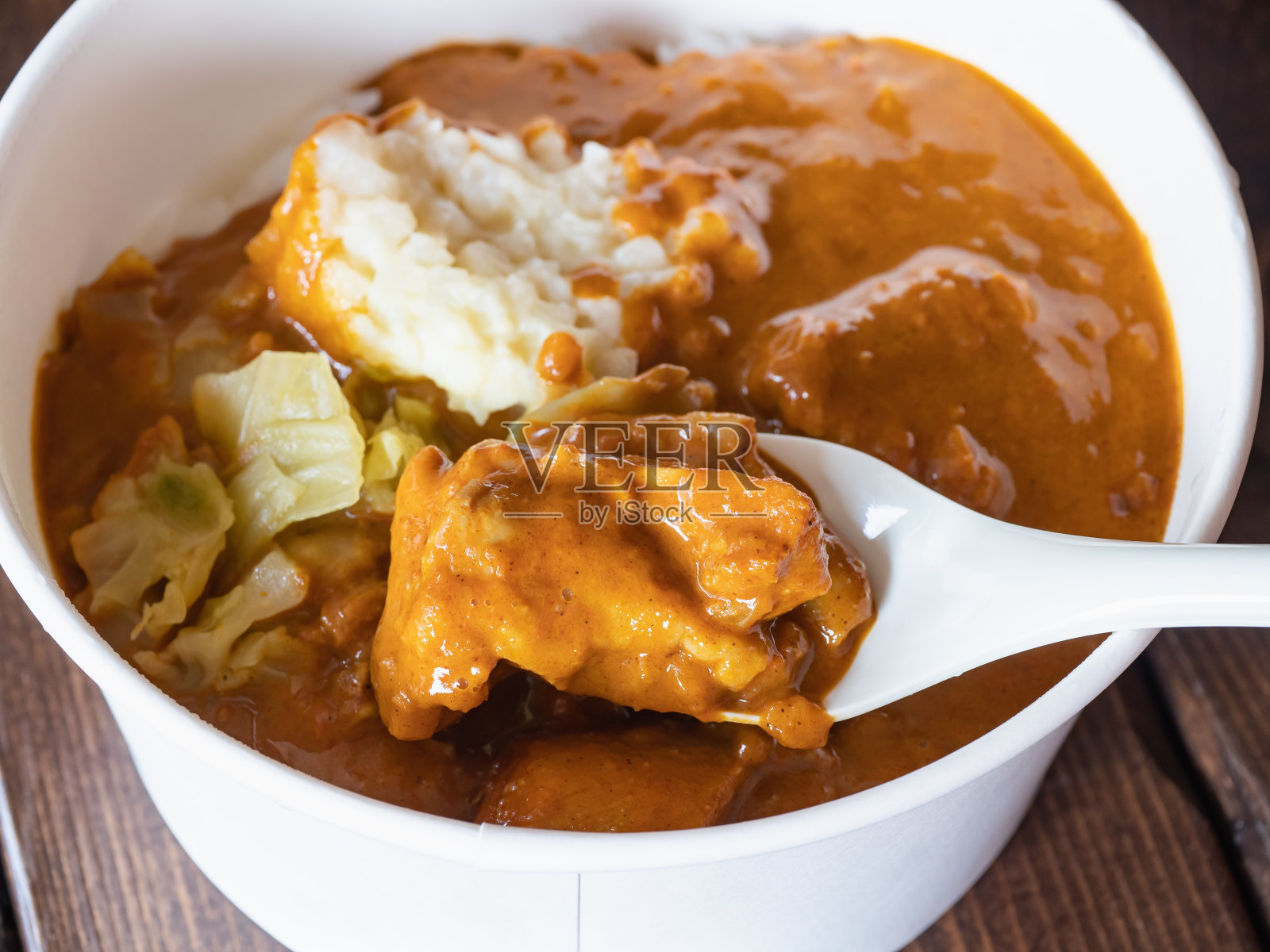 黄油咖喱鸡和白米饭的便当盒。鸡的特写。照片摄影图片