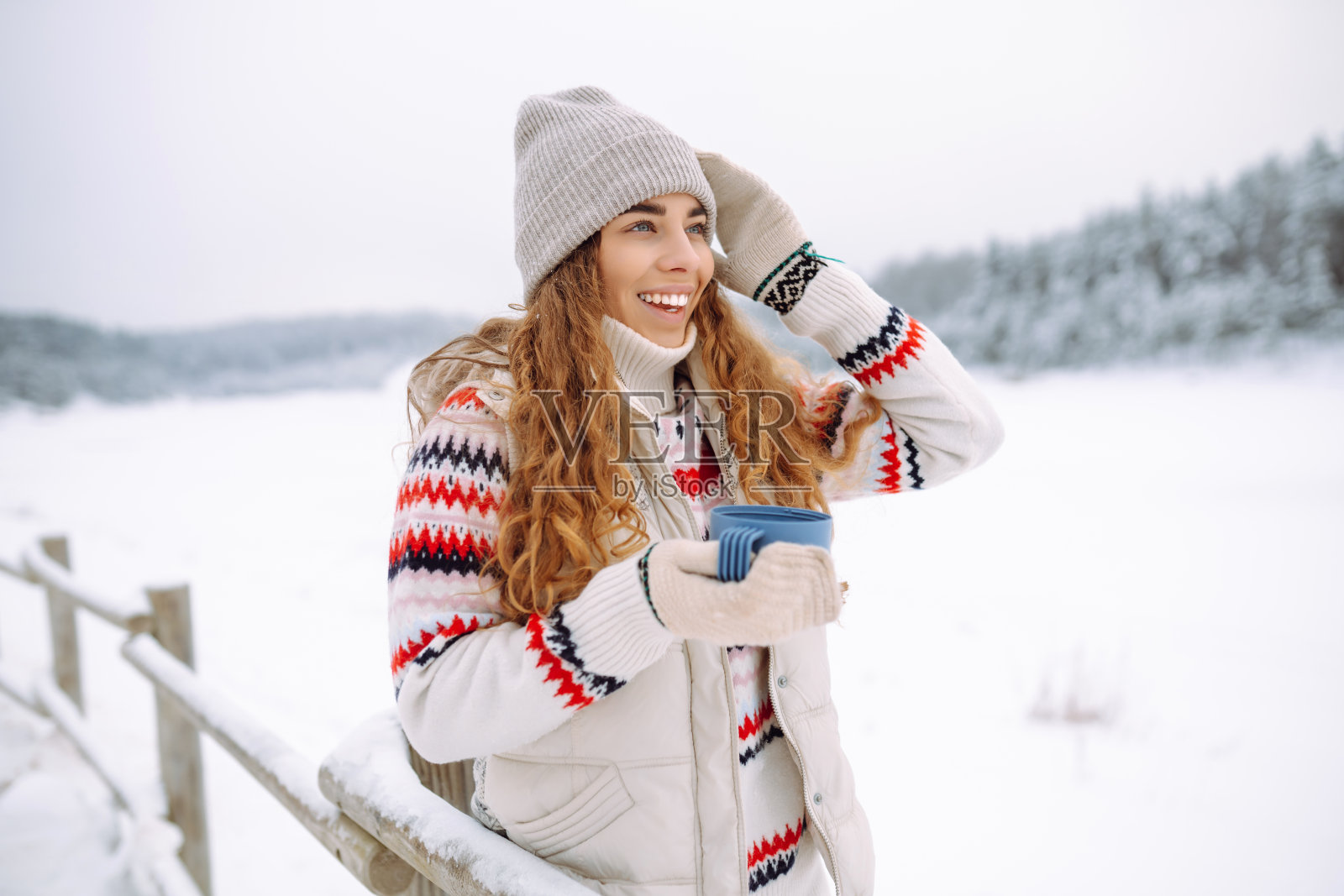 美丽的年轻女子用保温瓶喝茶。照片摄影图片