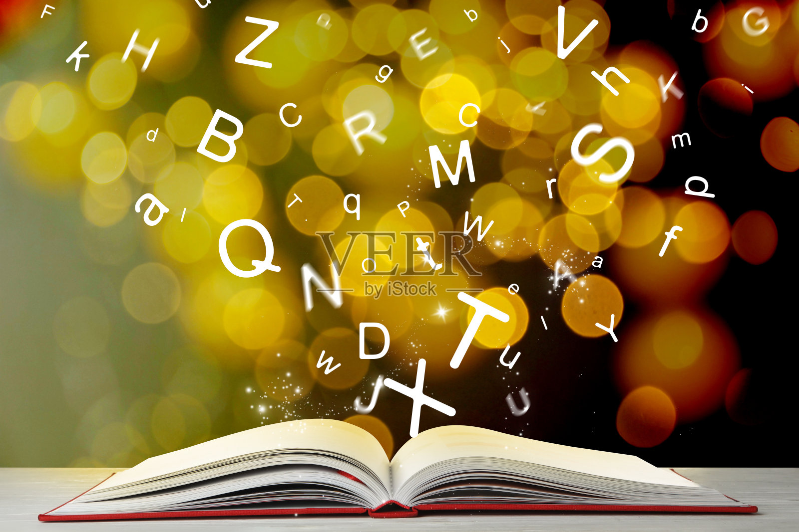 信件从桌上打开的书里飞出来,有散景效果照片摄影图片