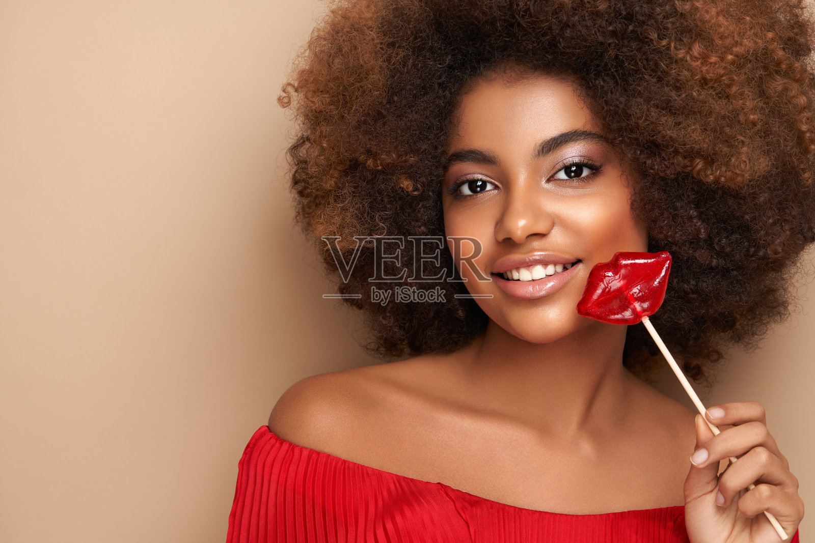 美丽的非洲女孩的肖像,嘴唇形状的棒棒糖照片摄影图片