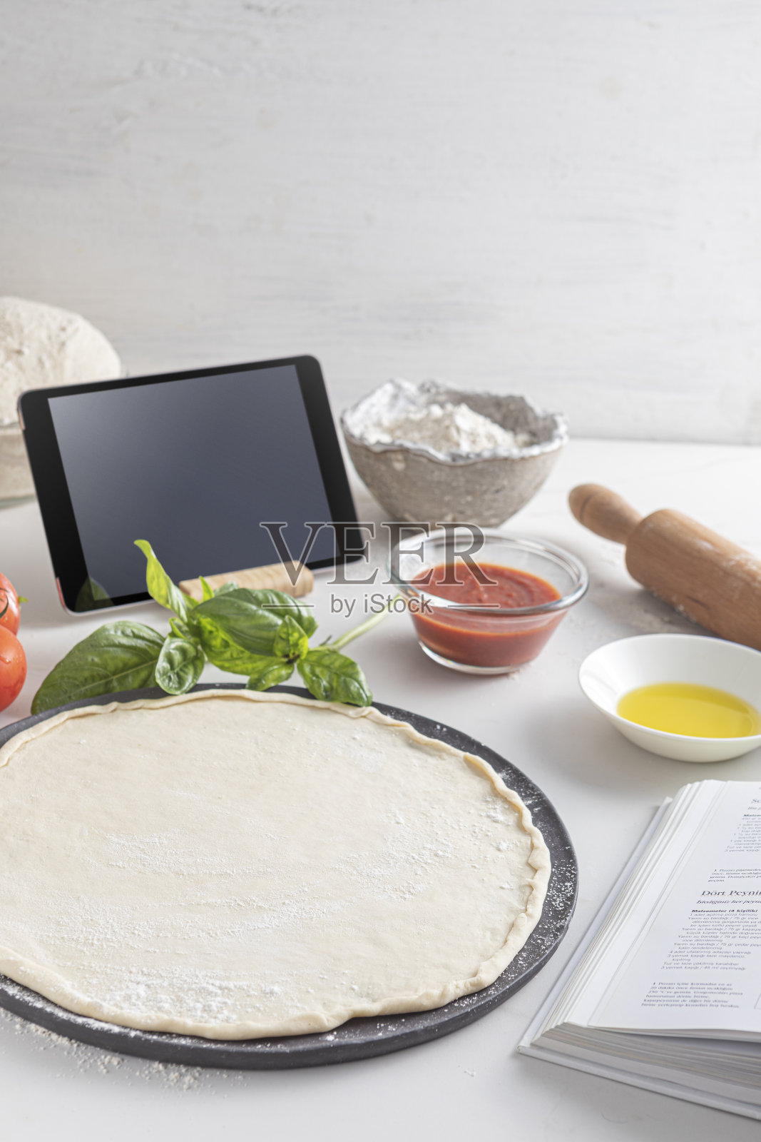 比萨的生面团,配料:番茄酱、生面团、马苏里拉奶酪、西红柿、罗勒、橄榄油、香料,放在质朴的大理石餐桌上照片摄影图片