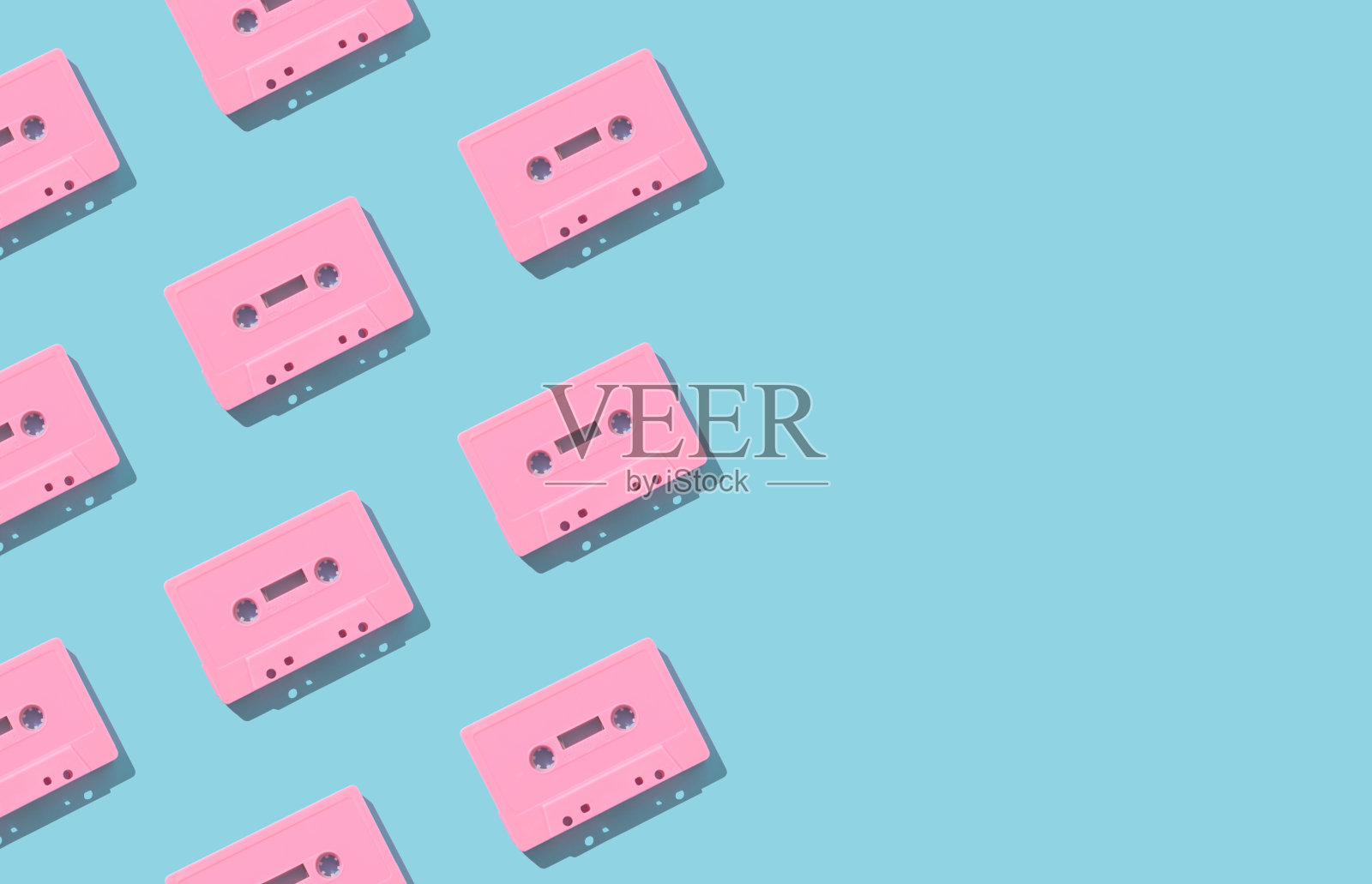 图案制成的复古粉红色的音频磁带浅蓝色的背景。复古科技的创意理念。80的审美。老式音频盒式磁带模式的想法。复古的怀旧。平的。照片摄影图片