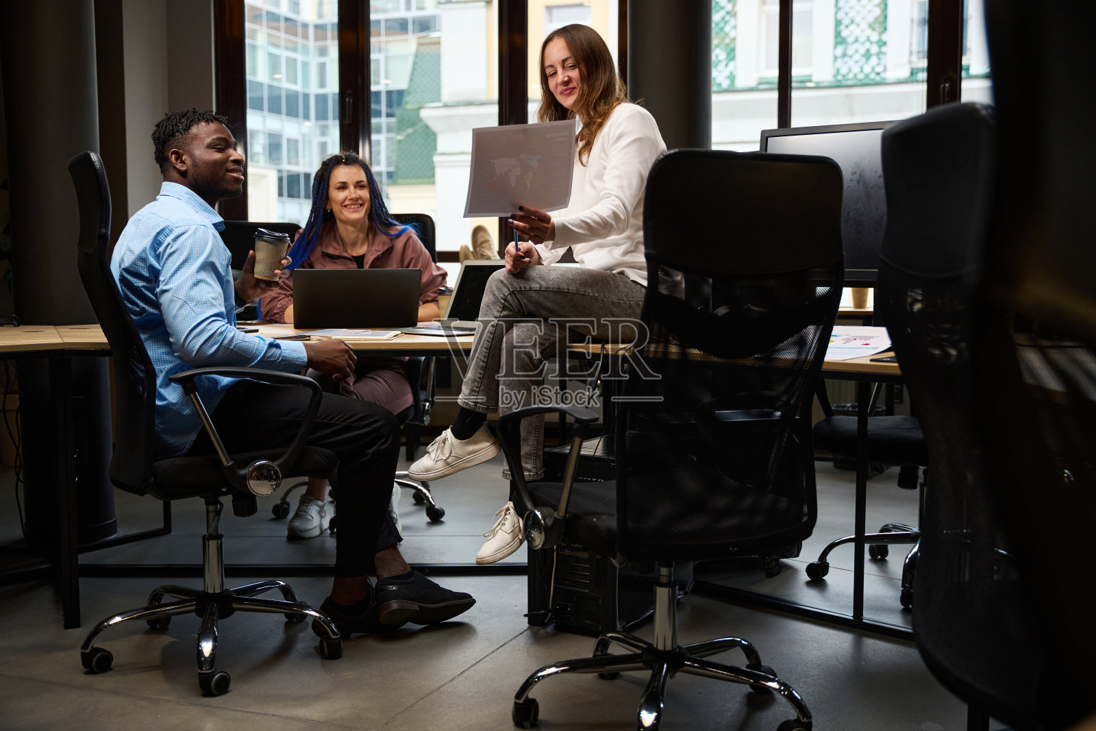 男同事和女同事坐在舒适的椅子上讨论新的公司标志照片摄影图片