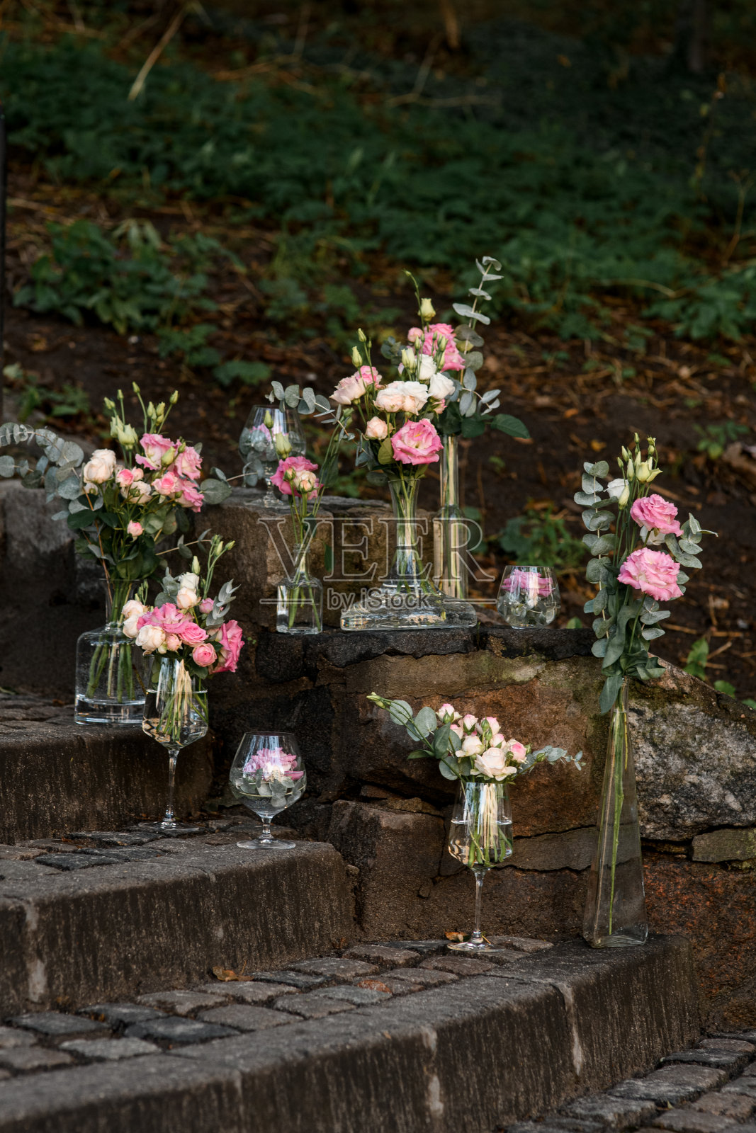 街道上的石阶上摆放着粉红色和白色的鲜花,还有水晶花瓶照片摄影图片