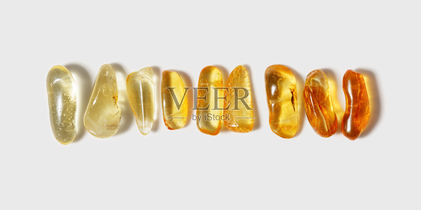 这套琥珀色的宝石在白色的背景上渐变,风格简约的设计理念,潮流的图案。天然宝石审美自然宝石的黄色渐变色。极简风格照片摄影图片