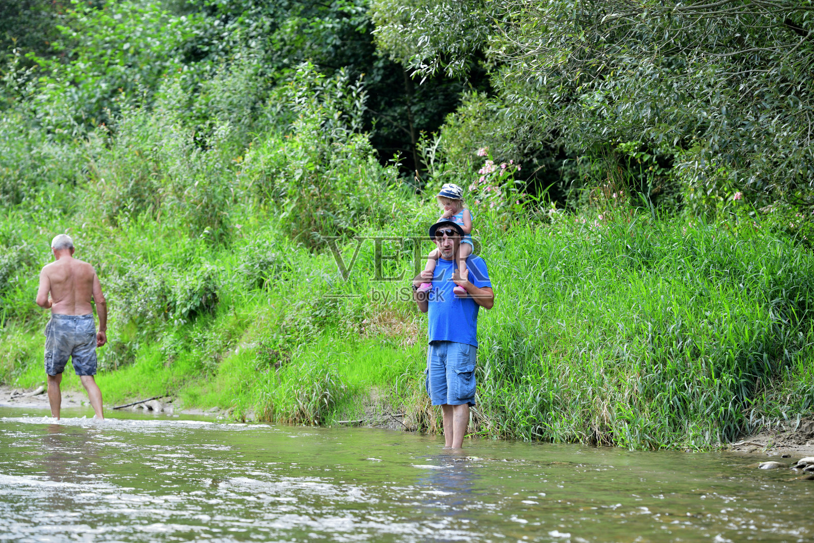 浅浅的河和在河边沙滩上野餐的游客照片摄影图片