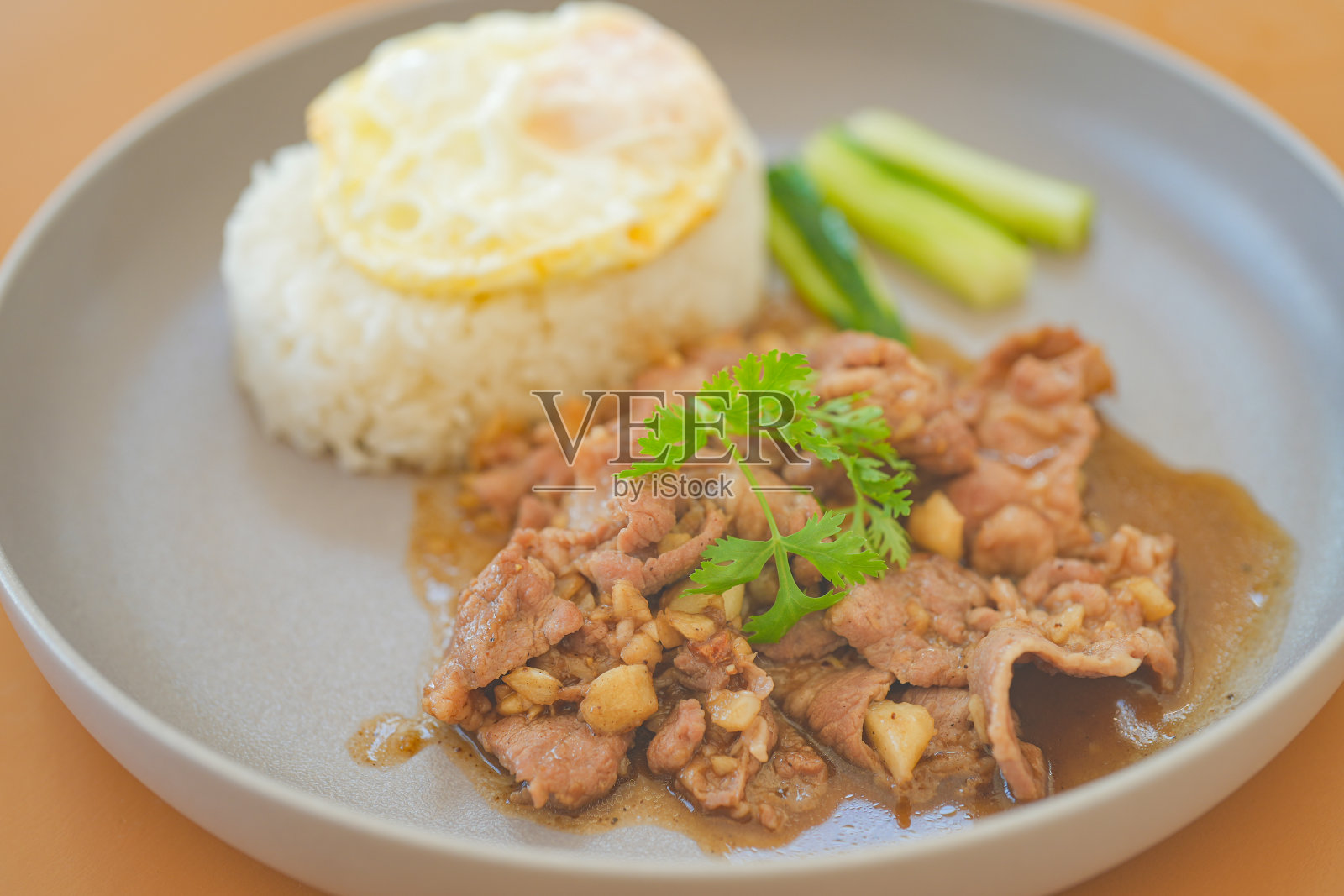 蒜蓉猪肉炒饭配上白盘煎蛋,泰国美食。照片摄影图片