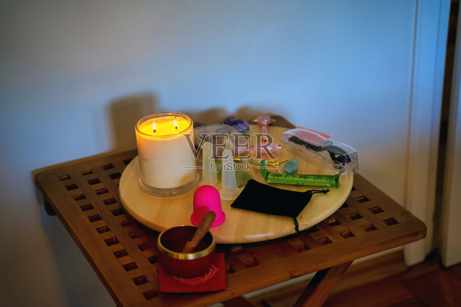 一盘装有蜡烛和玉按摩器等与针灸疗法相关的工具照片摄影图片