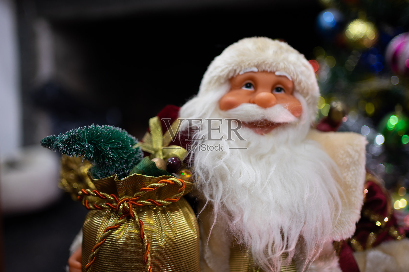 圣诞老人装饰的特写,背景是装饰过的圣诞树。照片摄影图片