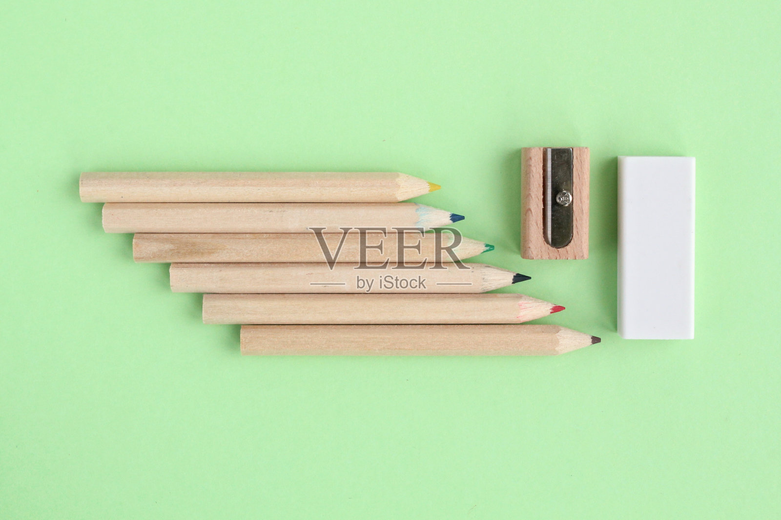 铅笔,木制手动卷笔刀和绿色背景的橡皮擦。回到学校的概念。一套用于教育、创意、绘画、爱好、艺术的写作工具。环保办公文具照片摄影图片