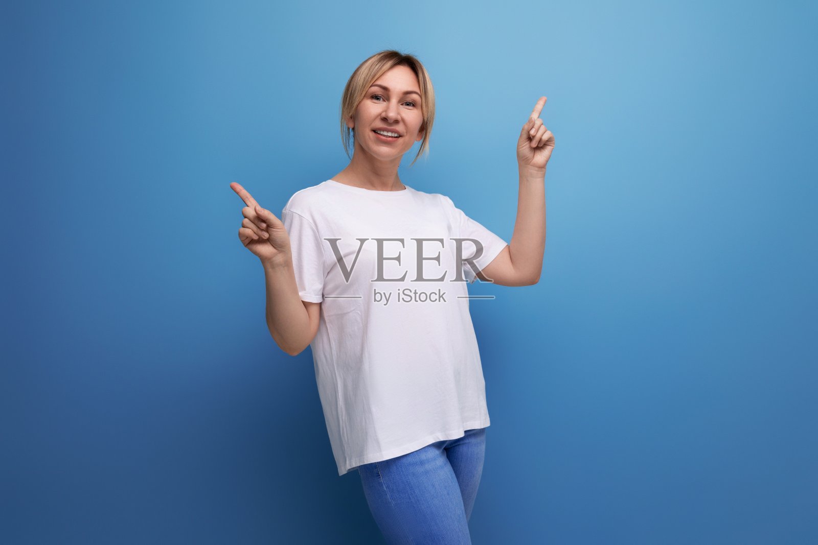 金发瘦削的女人穿着一件白色t恤,在上面印着信息照片摄影图片