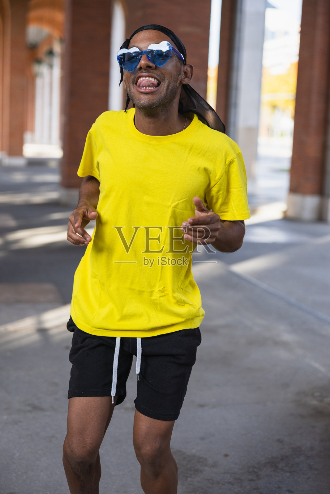 年轻的黑人男孩穿着城市服装在街上跳舞,垂直照片照片摄影图片