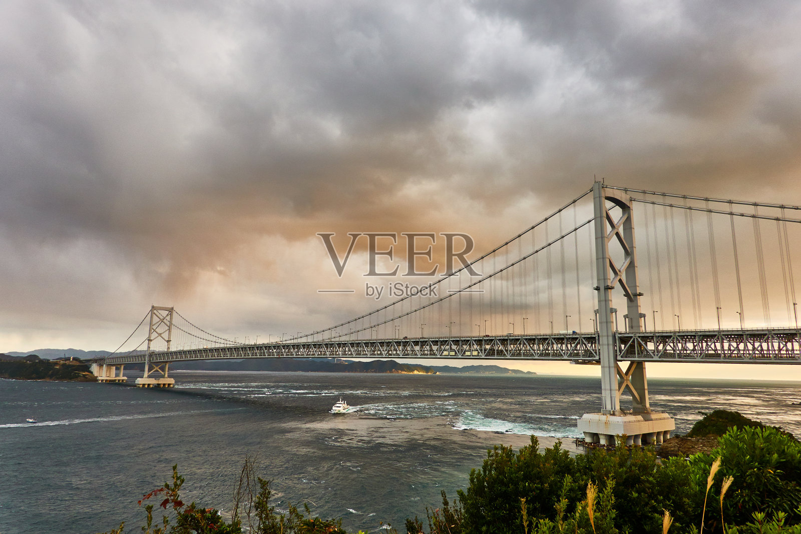 风景优美的海洋与桥梁建筑对抗戏剧性的天空照片摄影图片