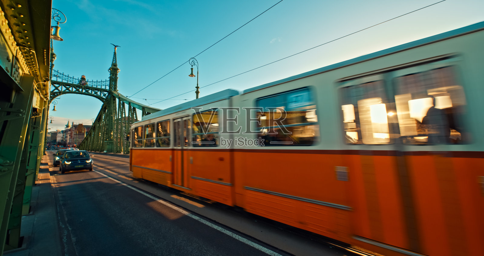 汽车和有轨电车在日落时在匈牙利布达佩斯自由桥上移动的模糊运动照片摄影图片