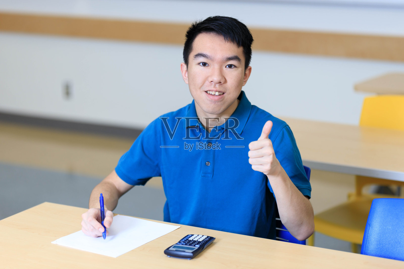 学生在课堂上写试卷时竖起大拇指照片摄影图片