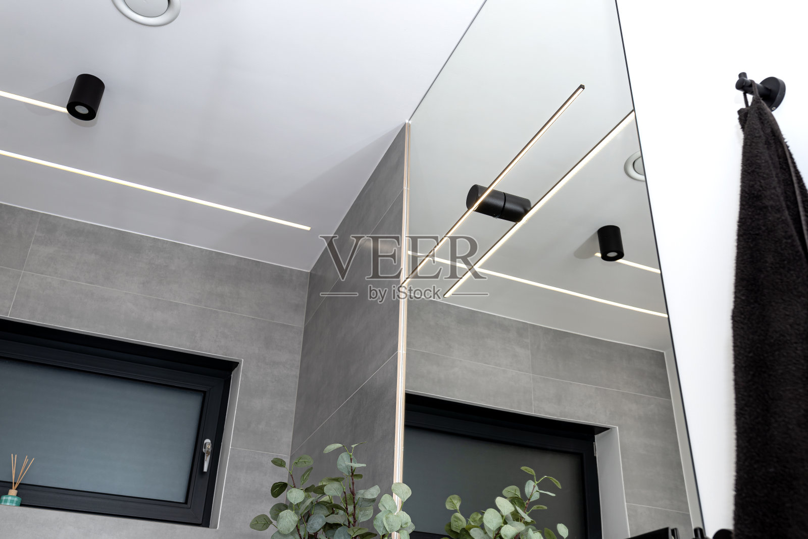 在现代浴室的墙壁和天花板上安装了LED灯条,可见通风调节器。照片摄影图片