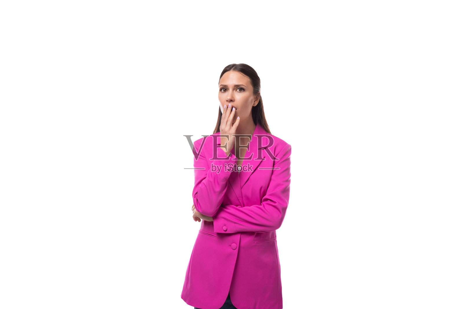 年轻、整洁、黑发、成功的女老板穿着一件粉色夹克,若有所思地看着镜头照片摄影图片