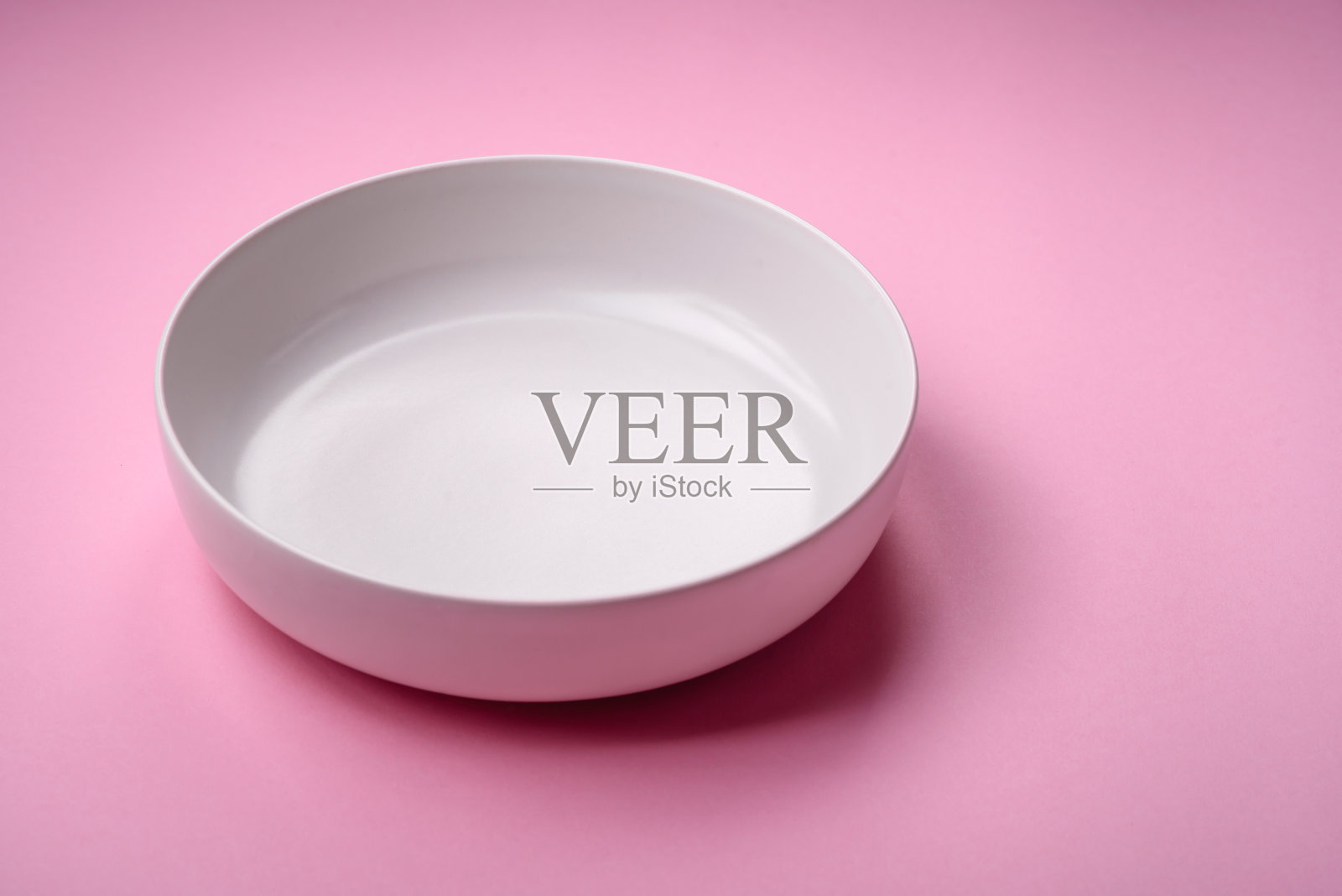 空的圆形陶瓷板在一个普通的背景上,平与复制空间照片摄影图片