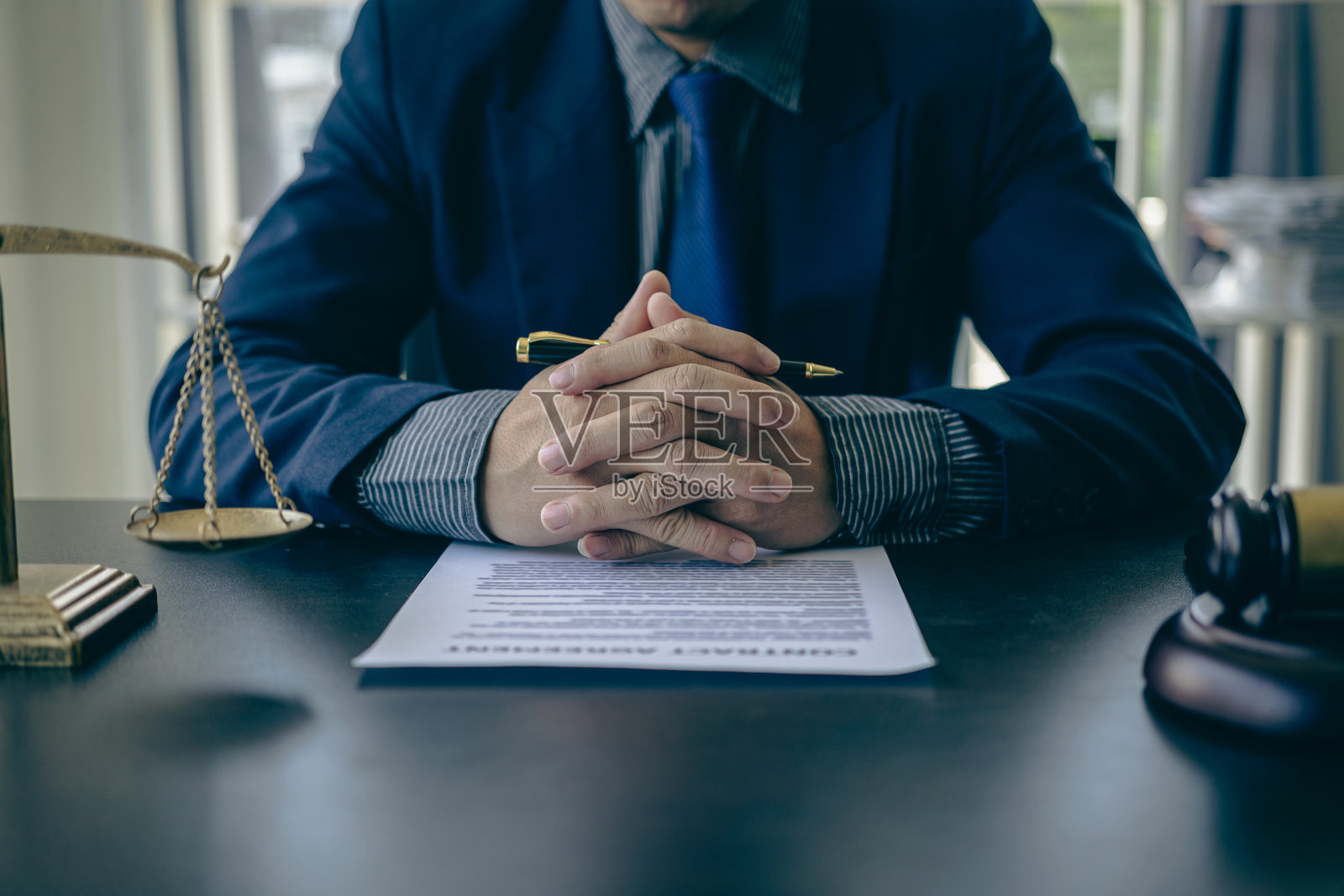 律师拿着合同文件和锤子工作的特写镜头,在正义的天平上,法律顾问的概念。照片摄影图片