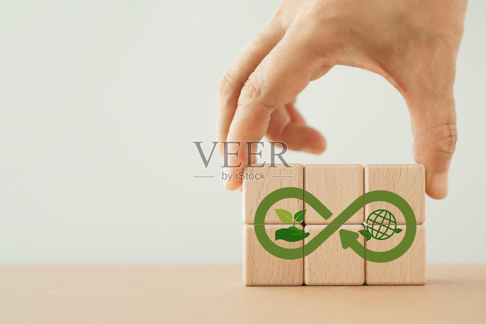 手工完成的木质立方体与绿色生态无限标志。秉持绿色生态无限、净零、循环经济、可再生能源和拯救世界的理念。可持续发展。包含复制空间照片摄影图片