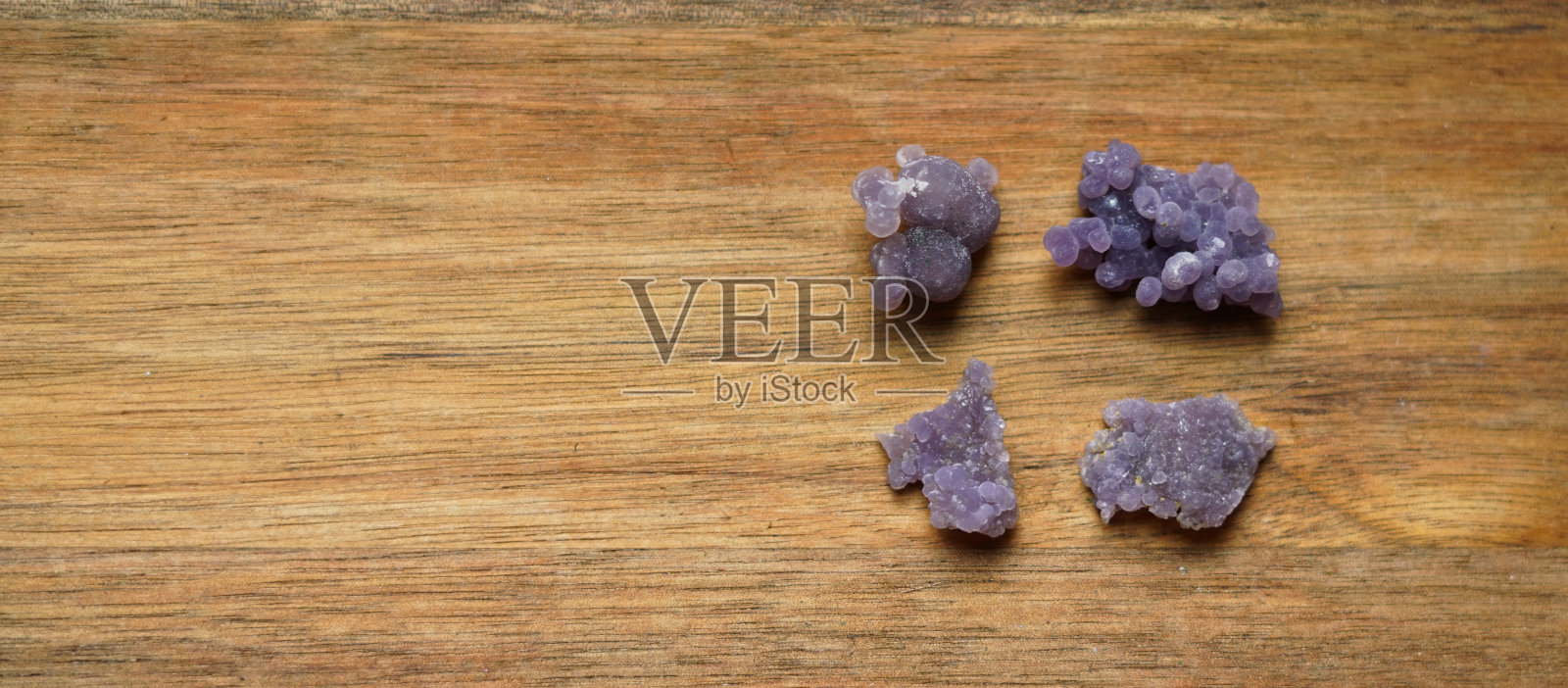 木质背景上的葡萄紫水晶。照片摄影图片