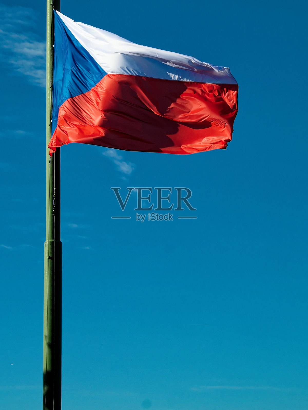 捷克共和国的国旗在旗杆上迎风飘扬,旗杆的背景是湛蓝的天空。照片摄影图片