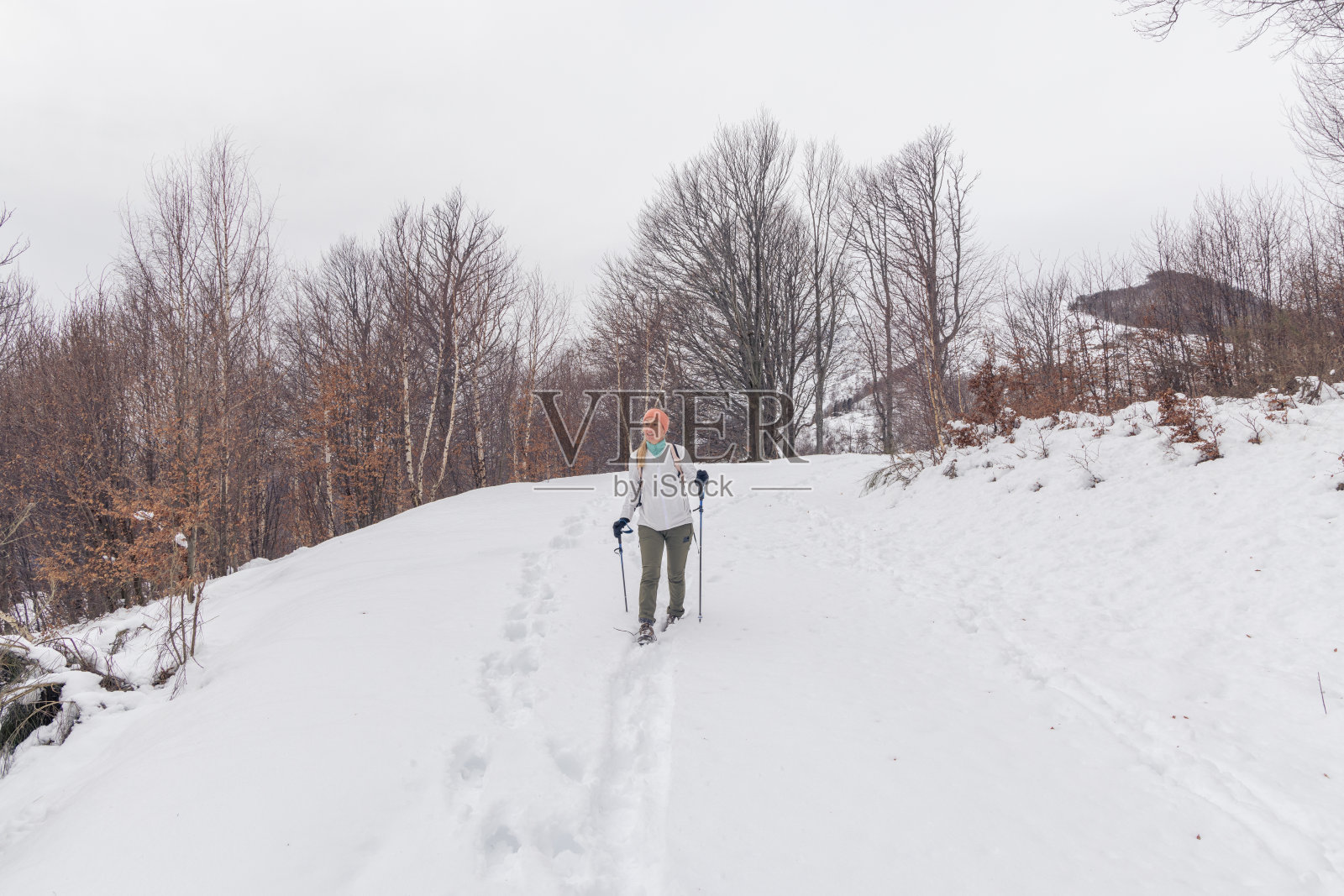 一位妇女沿着雪道徒步旅行照片摄影图片