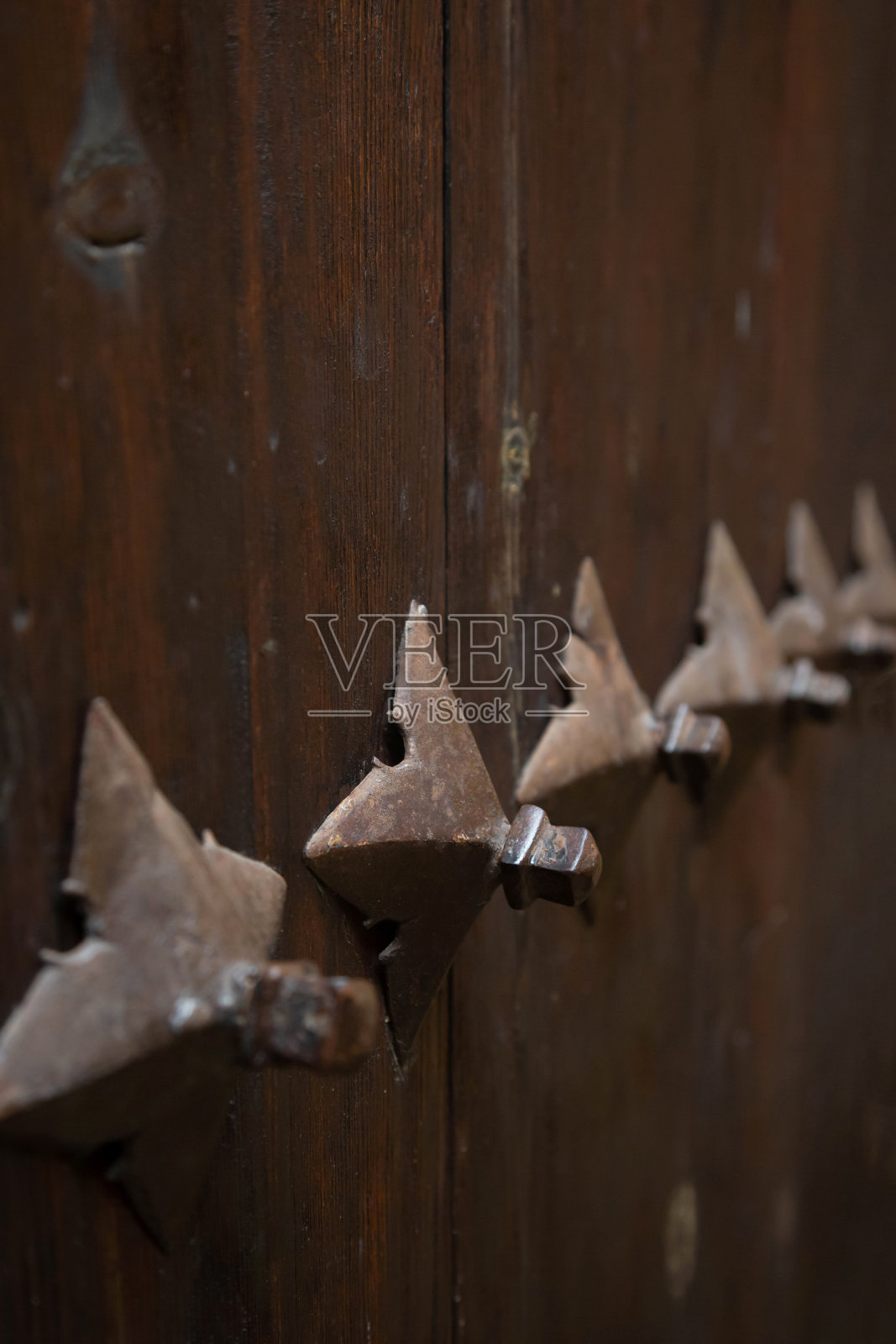 古老的中世纪木制铆接门,带有保护铁的细节。历史主题背景。照片摄影图片