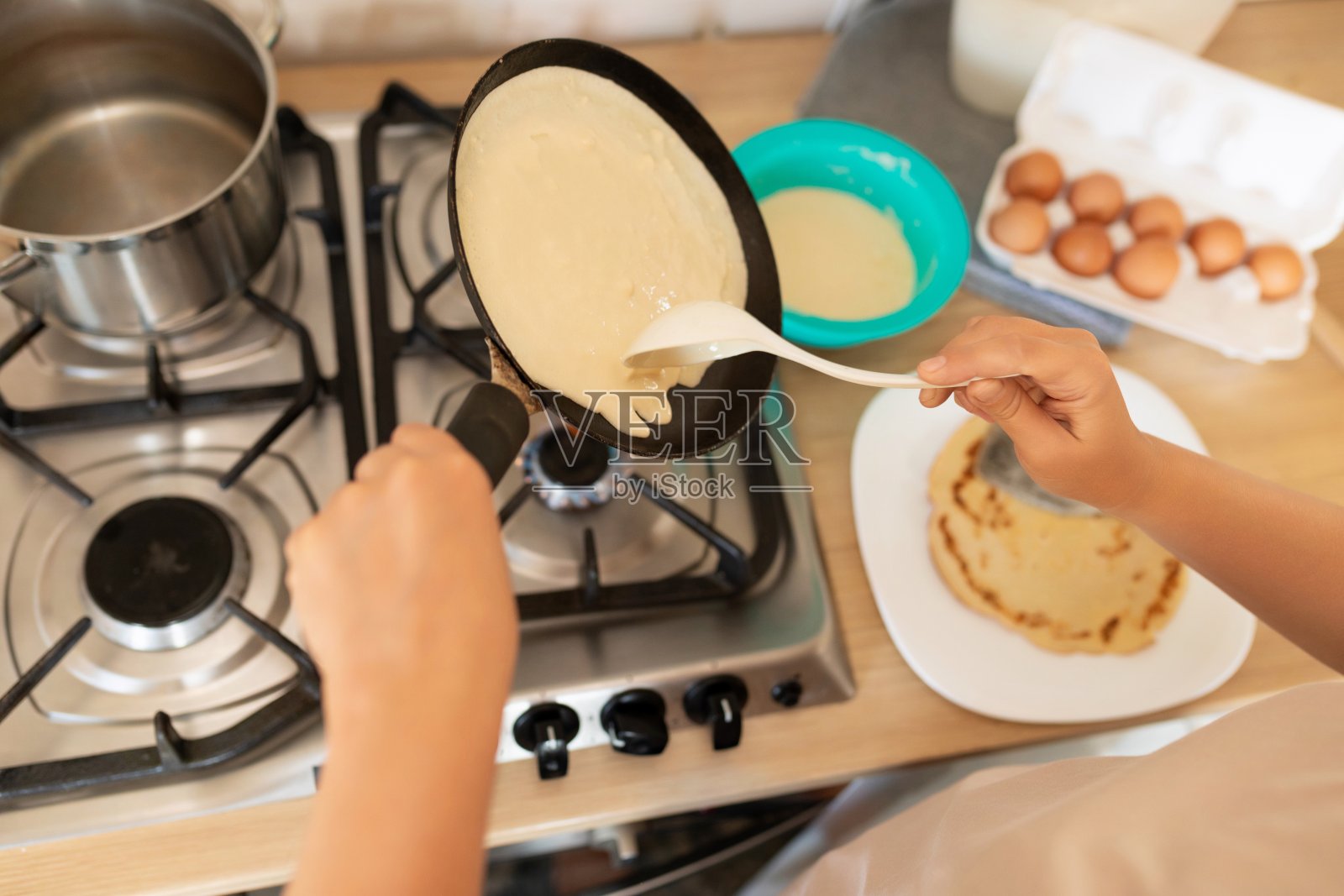 俯视图,在煎锅上煎薄饼的过程照片摄影图片