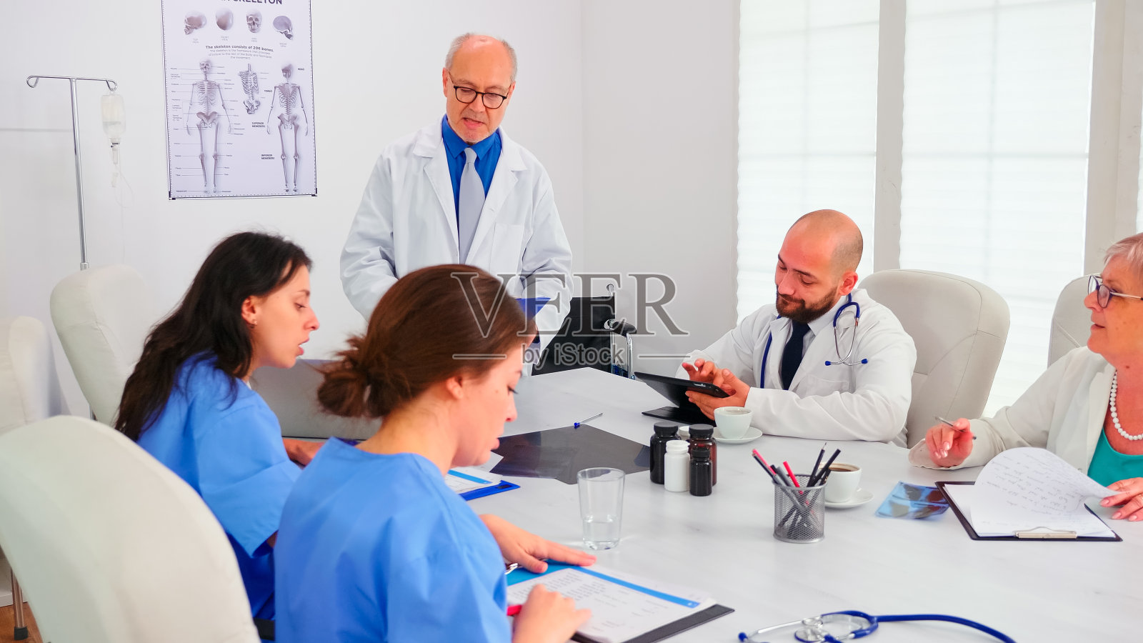 老年医学专家讲解病毒性疾病时,护士在做笔记照片摄影图片