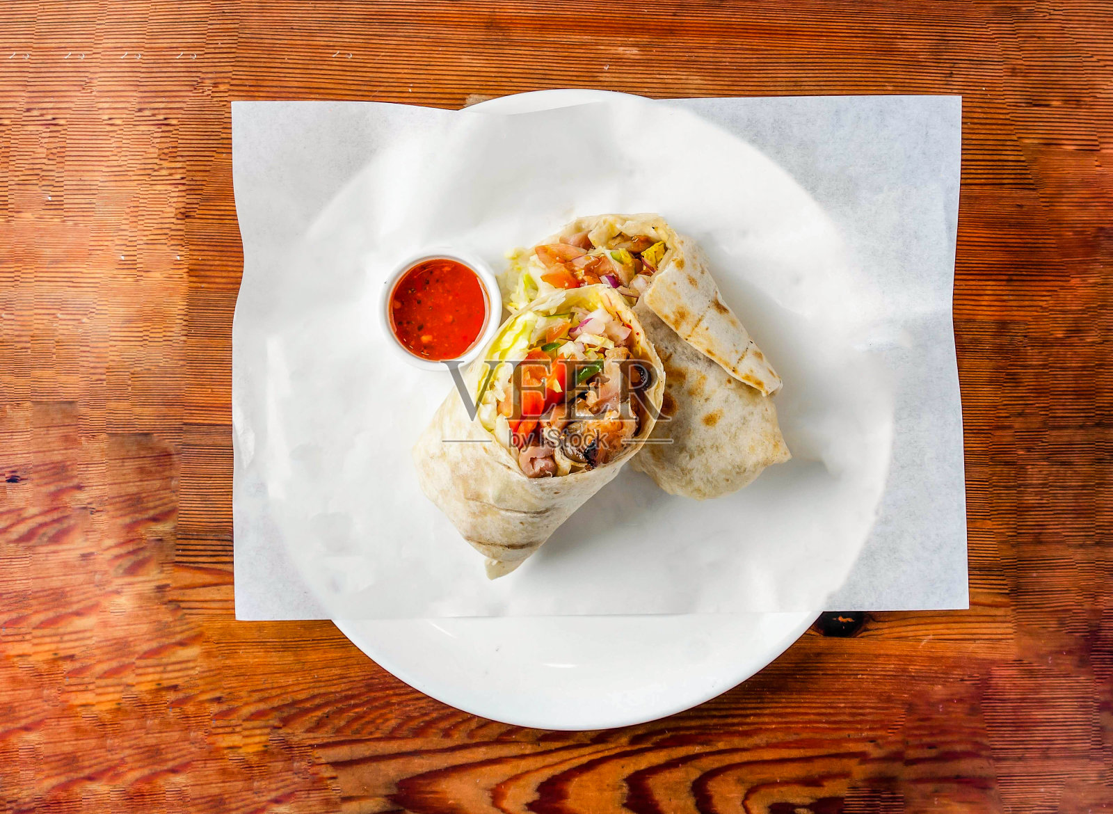 鸡肉卷中填满黄瓜,洋葱和西红柿,配上辣椒酱,在木制餐桌上俯瞰香港美食照片摄影图片