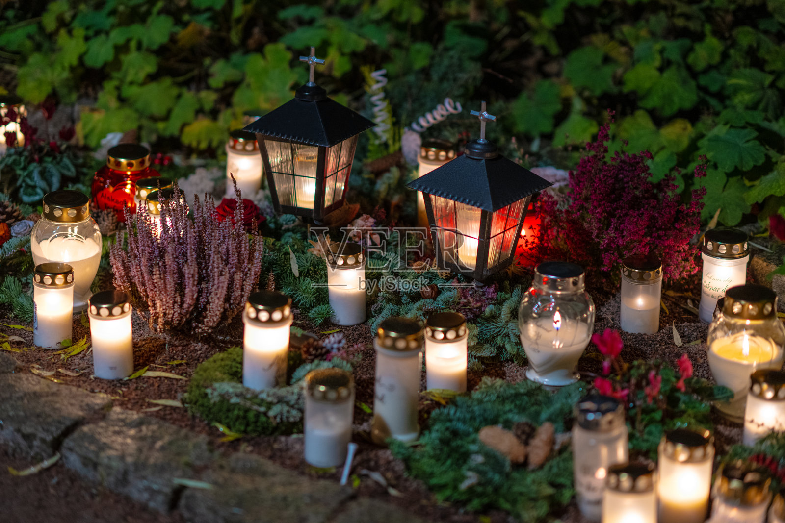 在万圣节前夕,墓地里的坟墓蜡烛…照片摄影图片