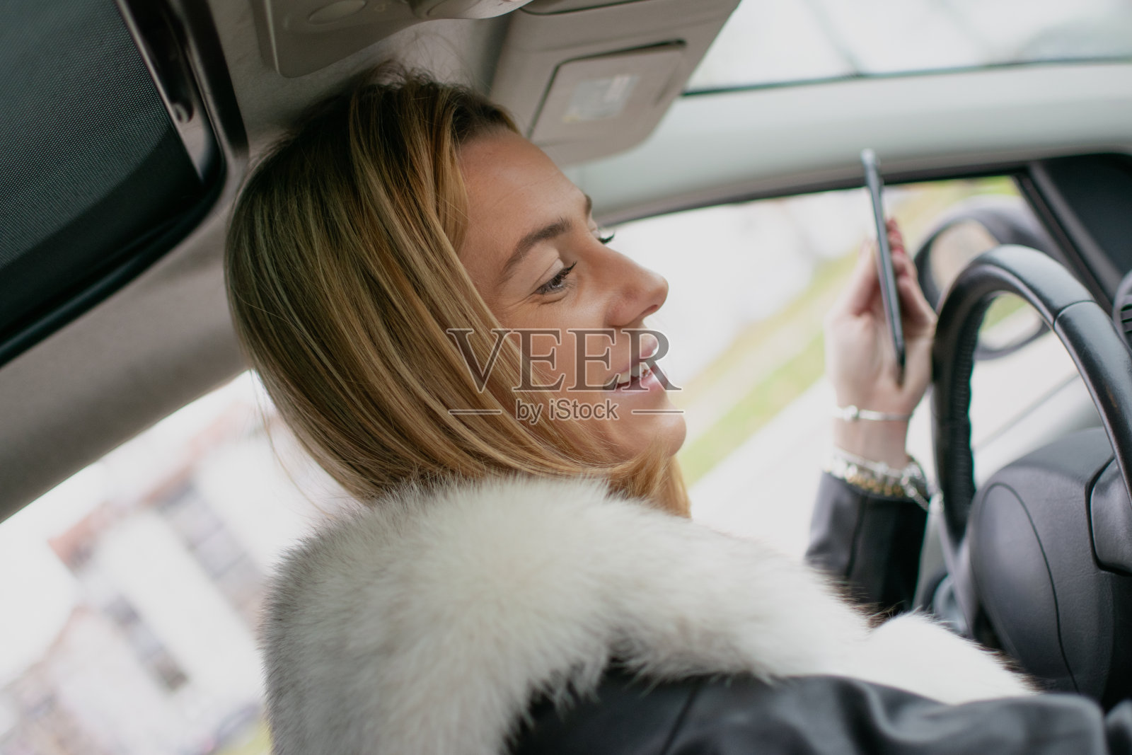 一个时髦的女孩坐在车里照片摄影图片