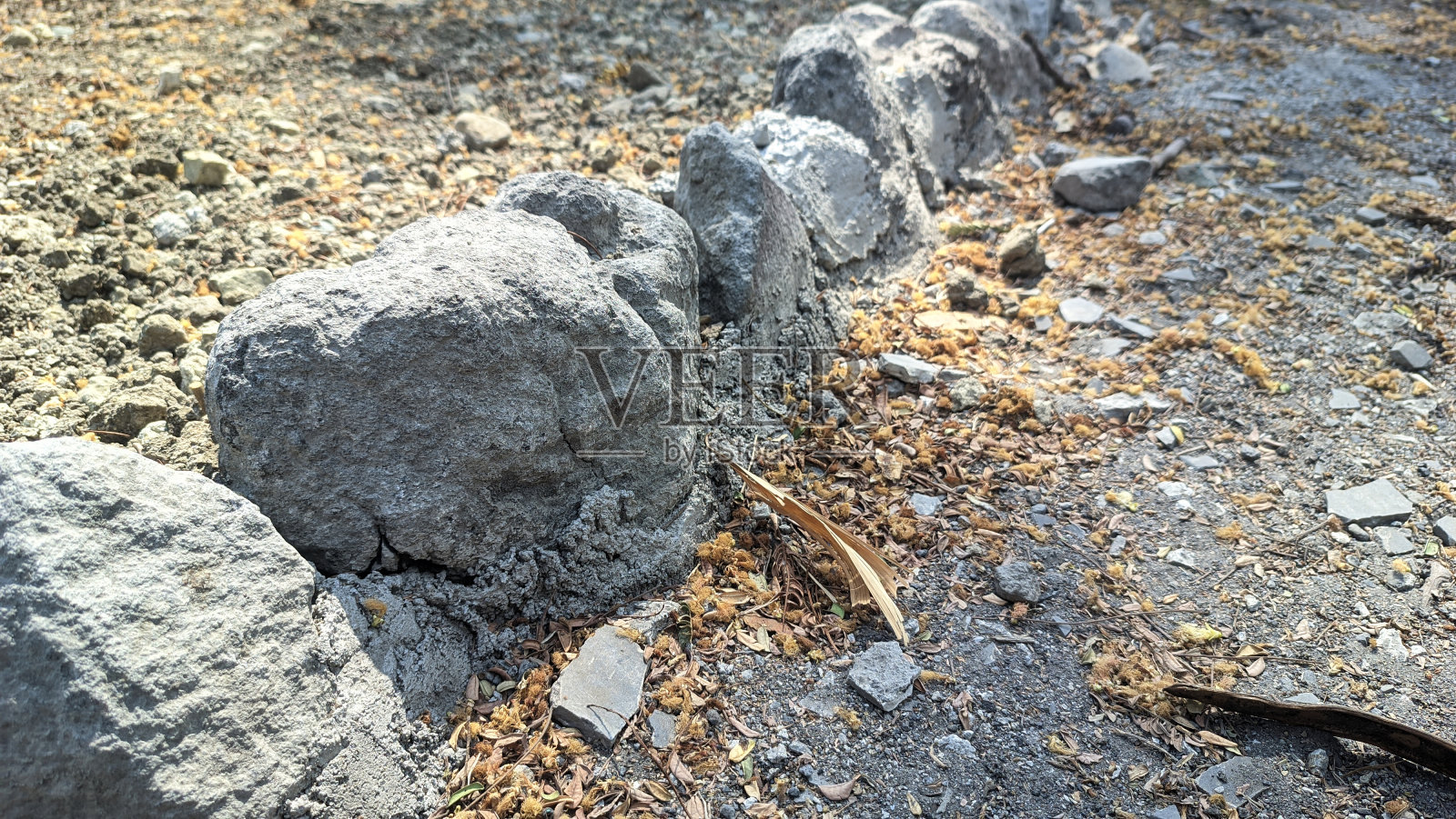 半埋在地下的石头结构照片摄影图片