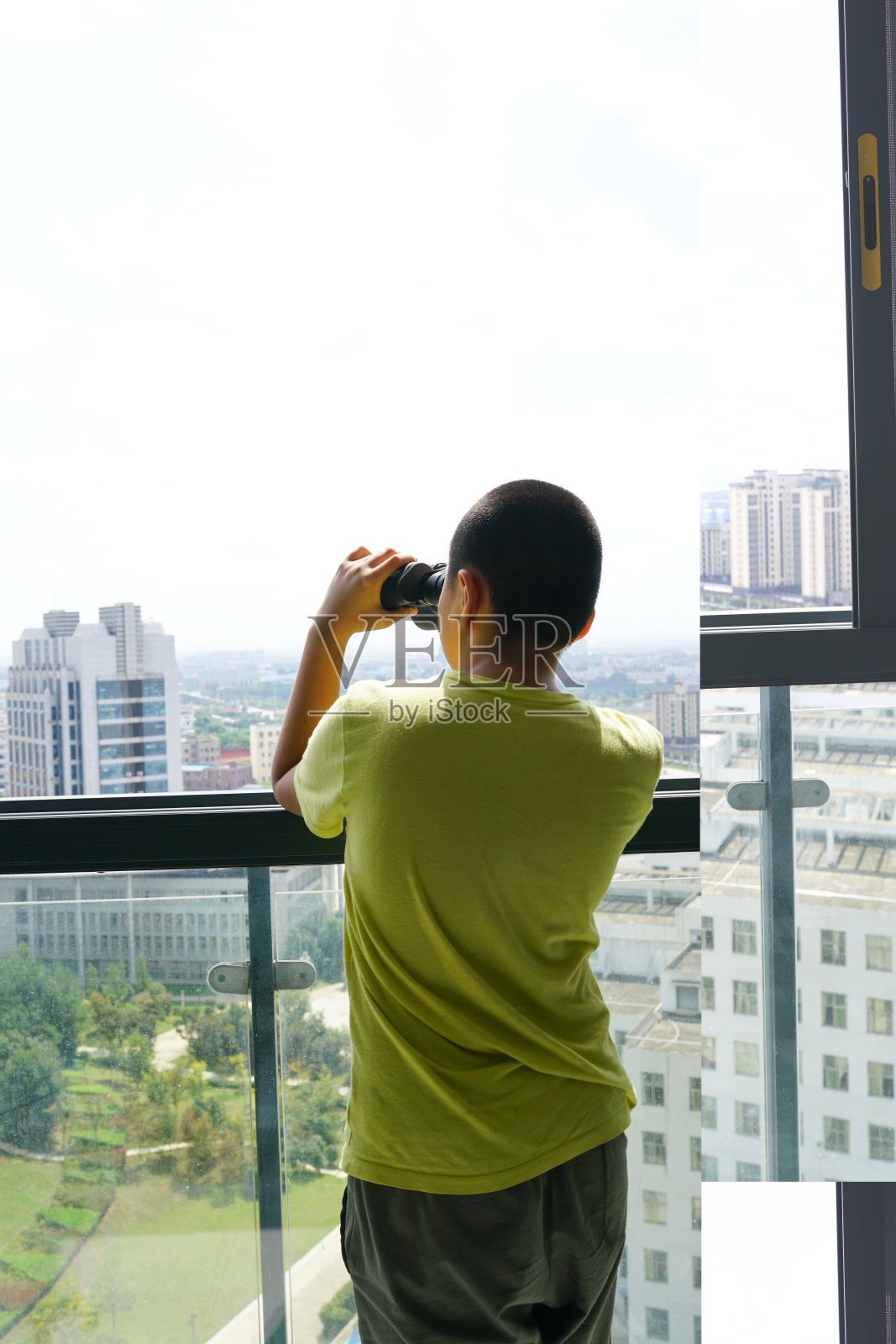 小孩拿着望远镜在窗外看电视照片摄影图片