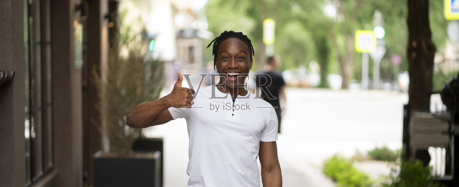 一个快乐的男人在街上对着镜头竖起大拇指照片摄影图片