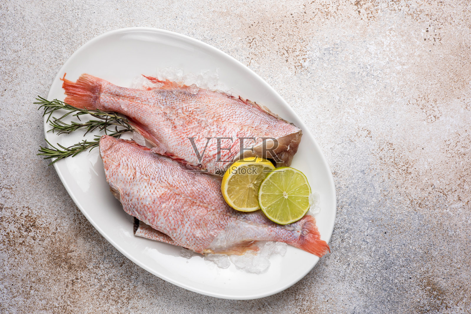 盘子里的粉红色海鲈鱼。特写镜头照片摄影图片