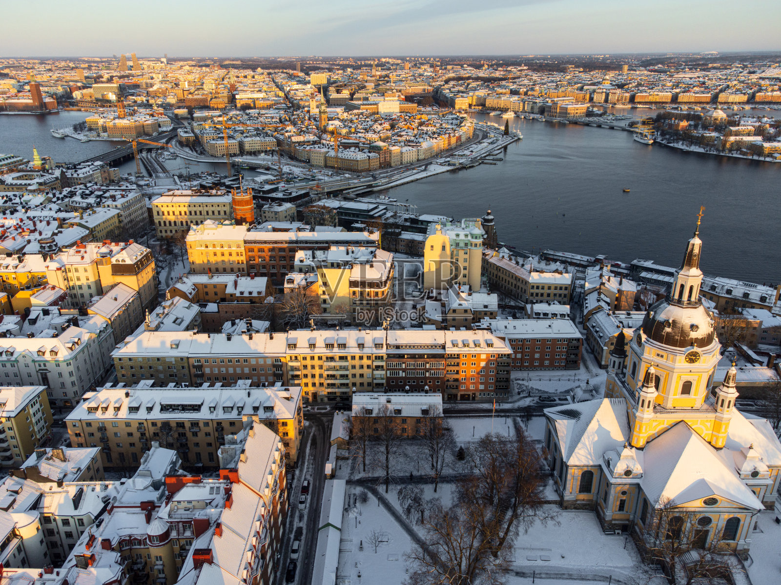 瑞典斯德哥尔摩市中心的全景,屋顶上有雪,天空晴朗,冬天的太阳很低。照片摄影图片
