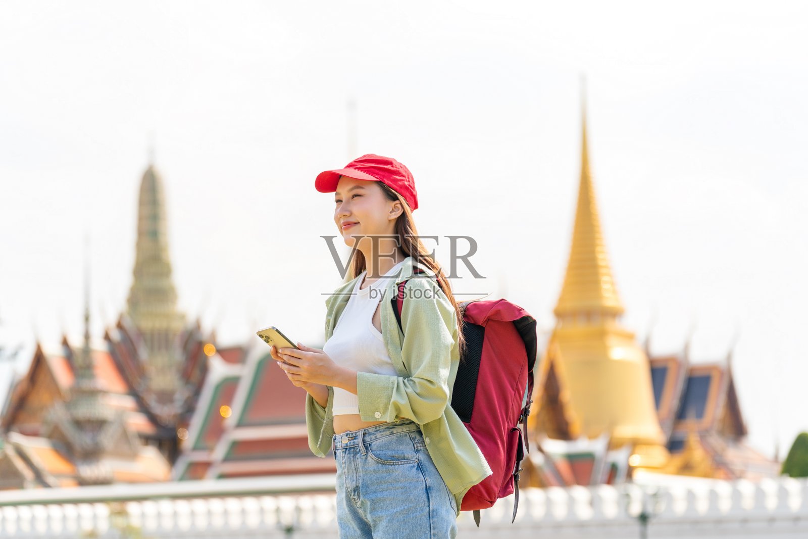 带着智能手机的亚洲女游客在吴佛祖和大皇宫外照片摄影图片