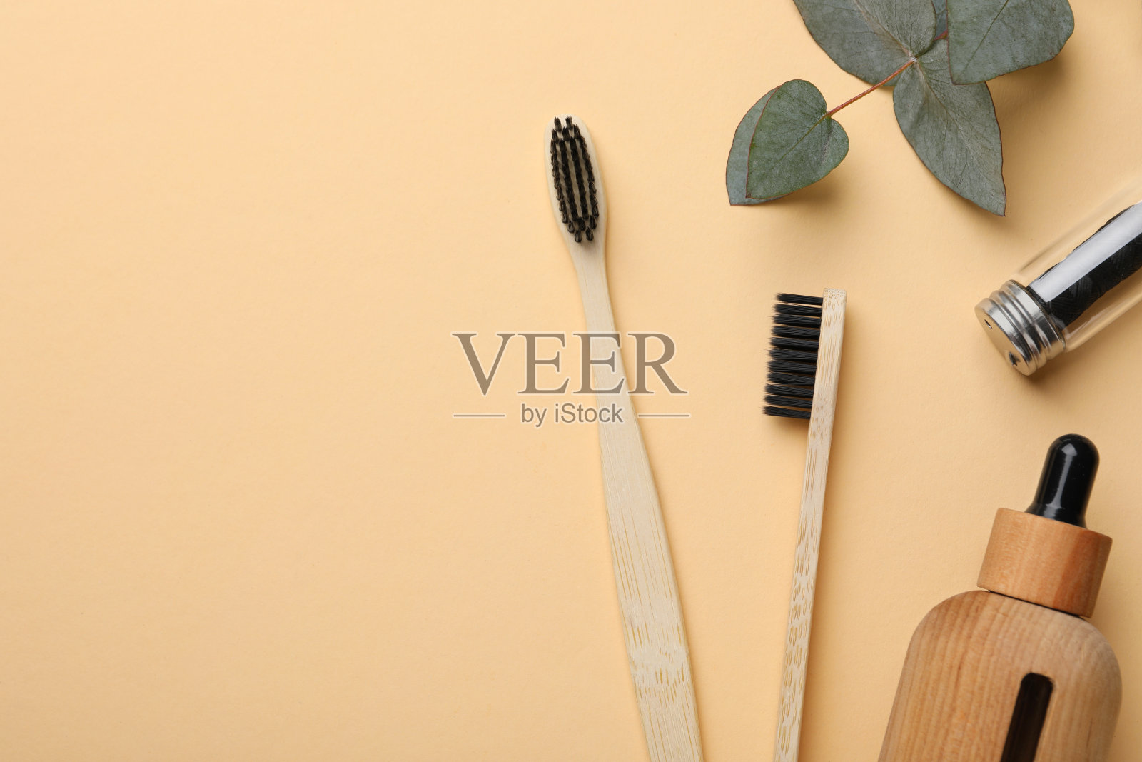 用竹牙刷在淡橙色背景上平铺构图,留出文字空间照片摄影图片