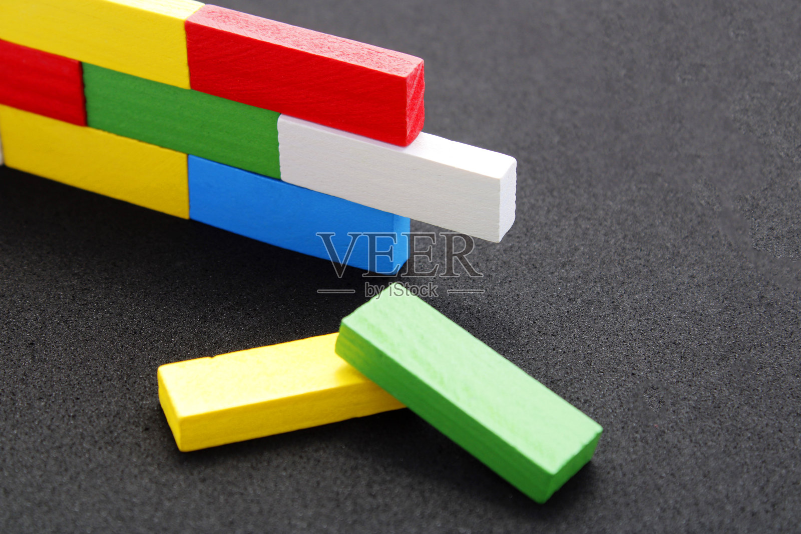 两个不同颜色的木条准备放置在其他木条旁边照片摄影图片